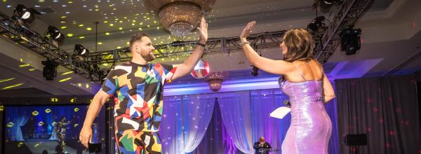 Mike Rivera high fives Jillian Carroll at the end of the runway at our 16th Annual Challenge Your Fashion presented by Pro Athlete.