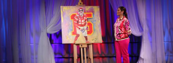 Artist Vania Soto looks upon her painting of Kansas City Chiefs quarterback Patrick Mahomes that she painted live during the duration of the 16th Annual Challenge Your Fashion presented by Pro Athlete.