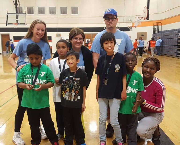 Youth basketball players and coaches posing in a YMCA gym
