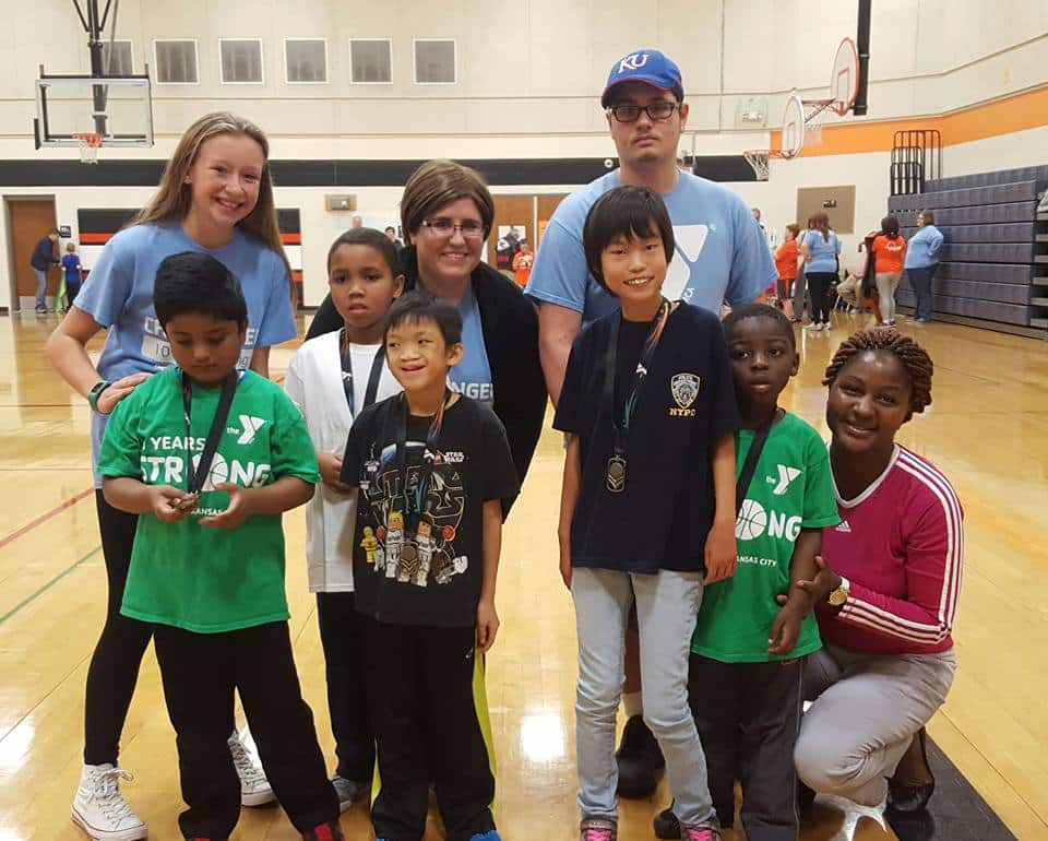 Youth basketball players and coaches posing in a YMCA gym