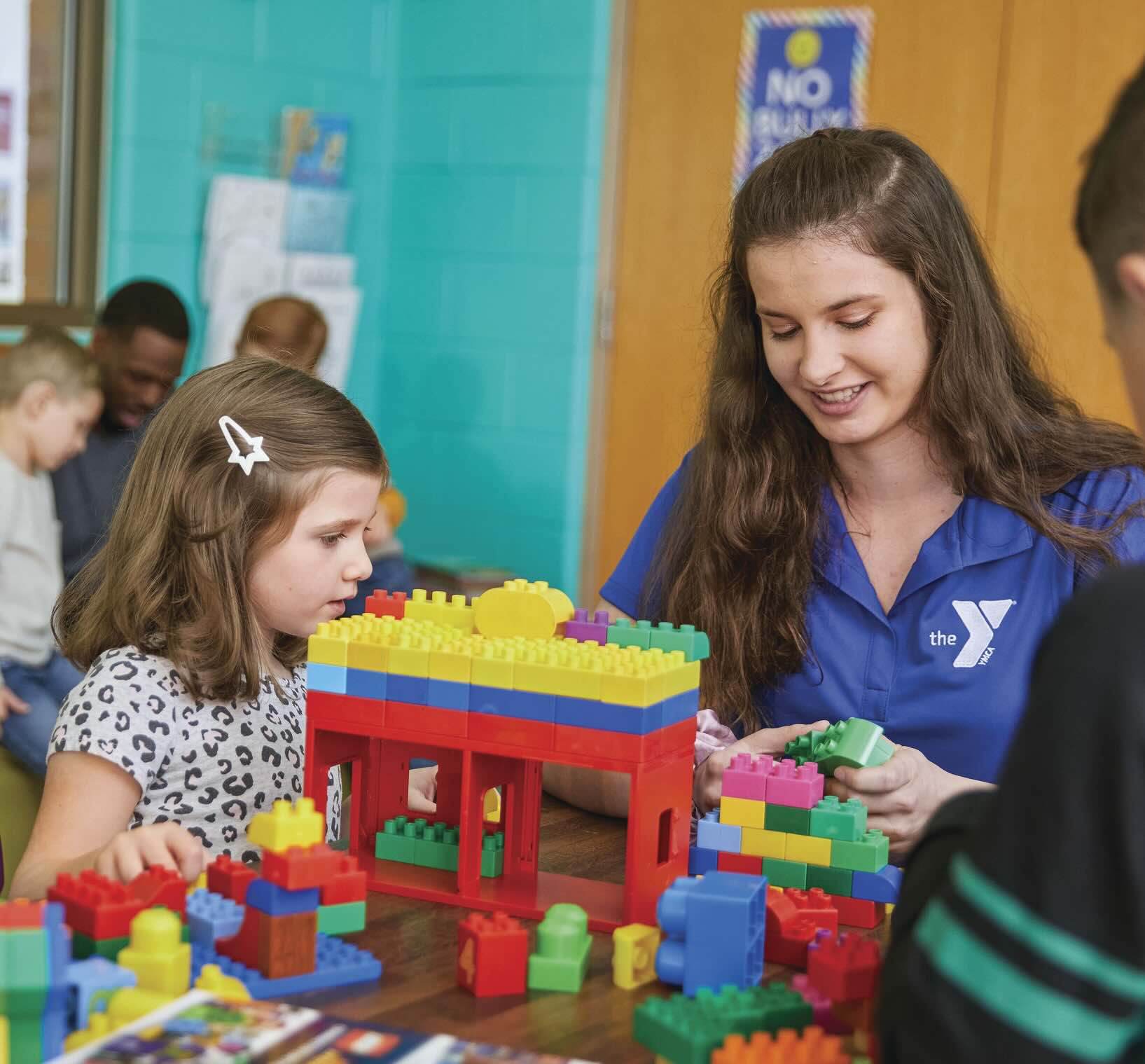 Teacher and student building legos together