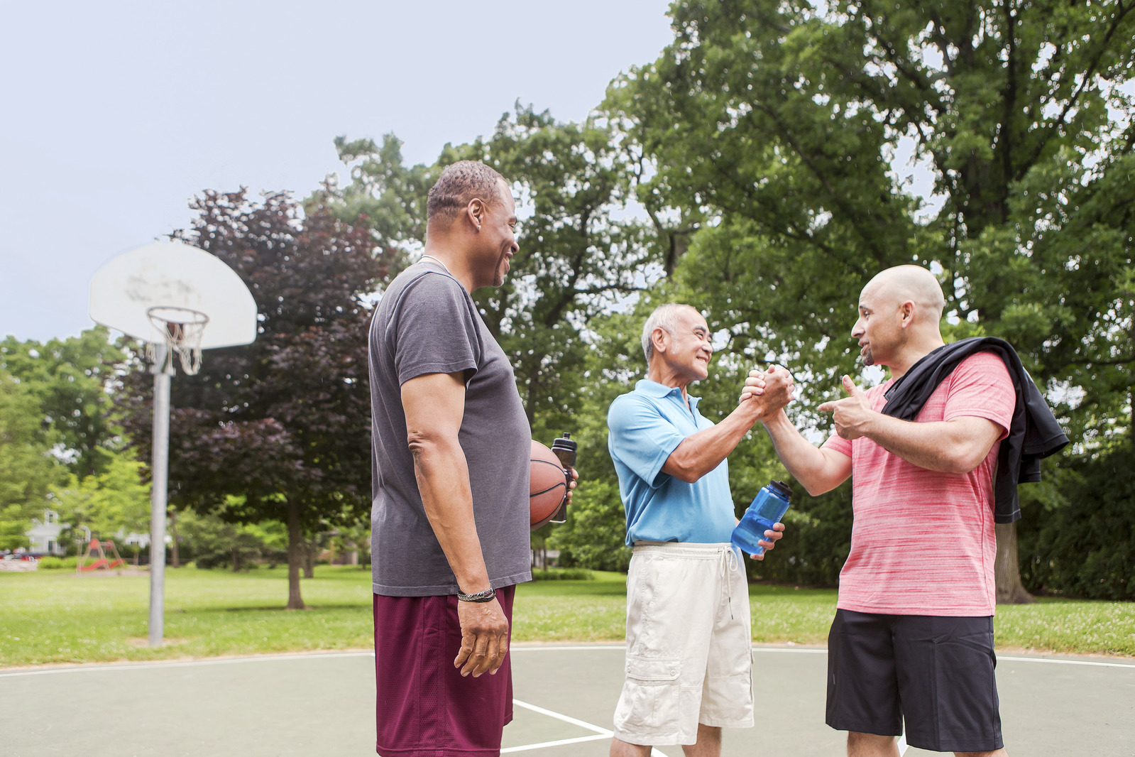 Group of 3 Kansas City YMCA members talking after a basketball game