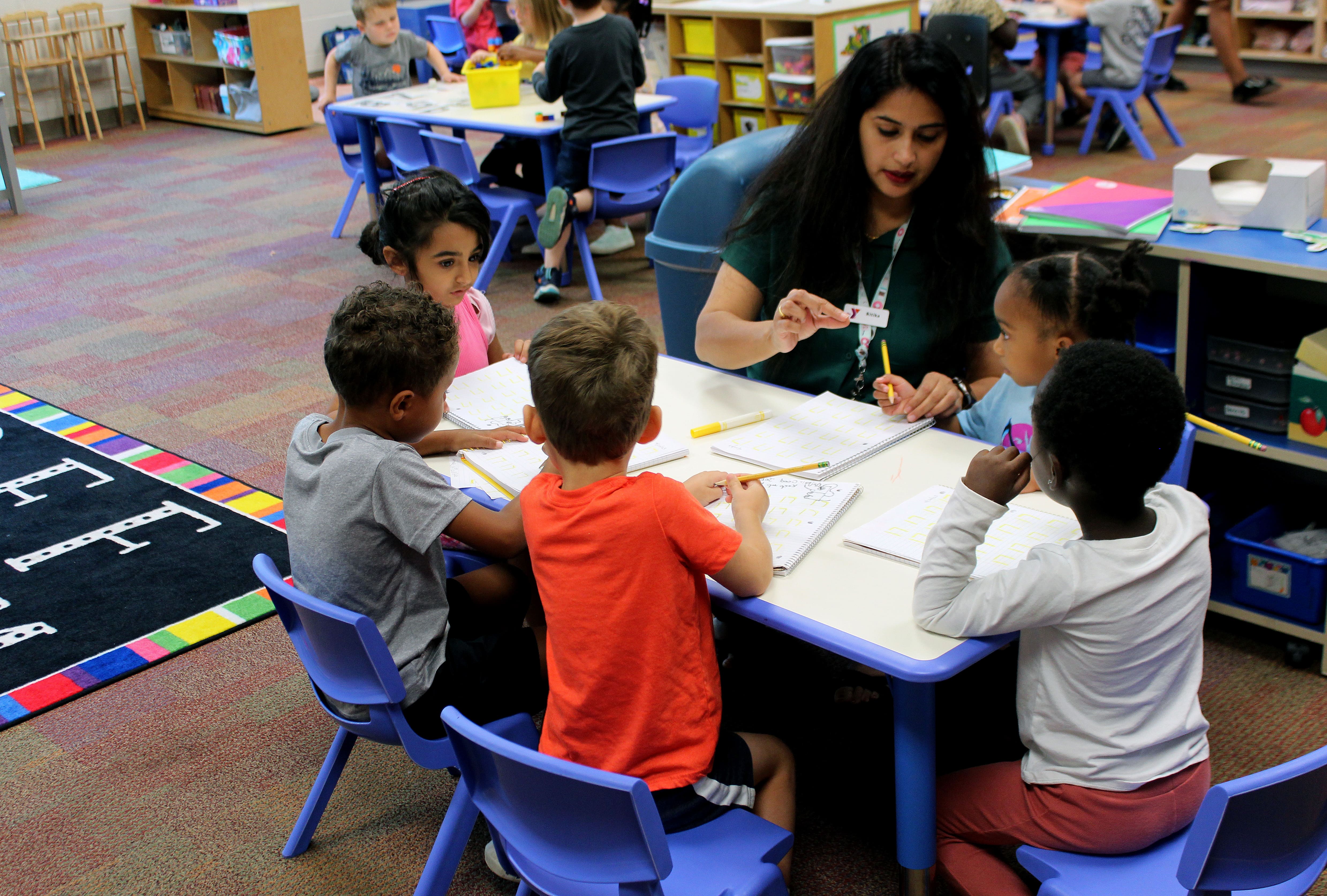 art teacher at table with five kids