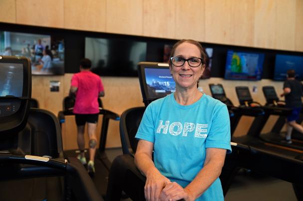 Jennie's standing in front of the gym treadmills at a Kansas City YMCA.