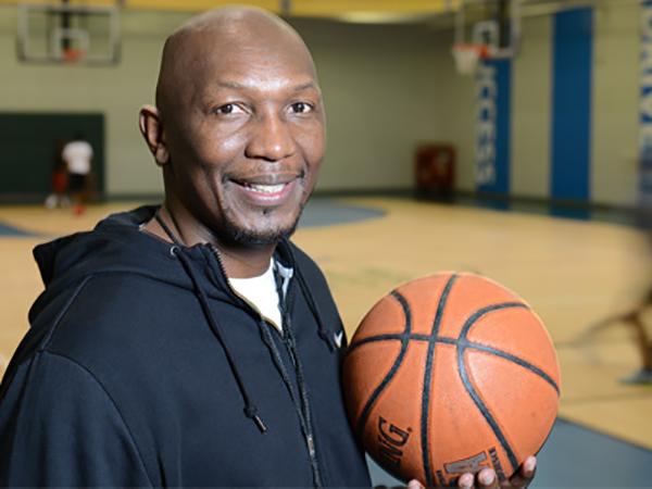 Fred holding a basketball in a basketball court in a Kansas City YMCA