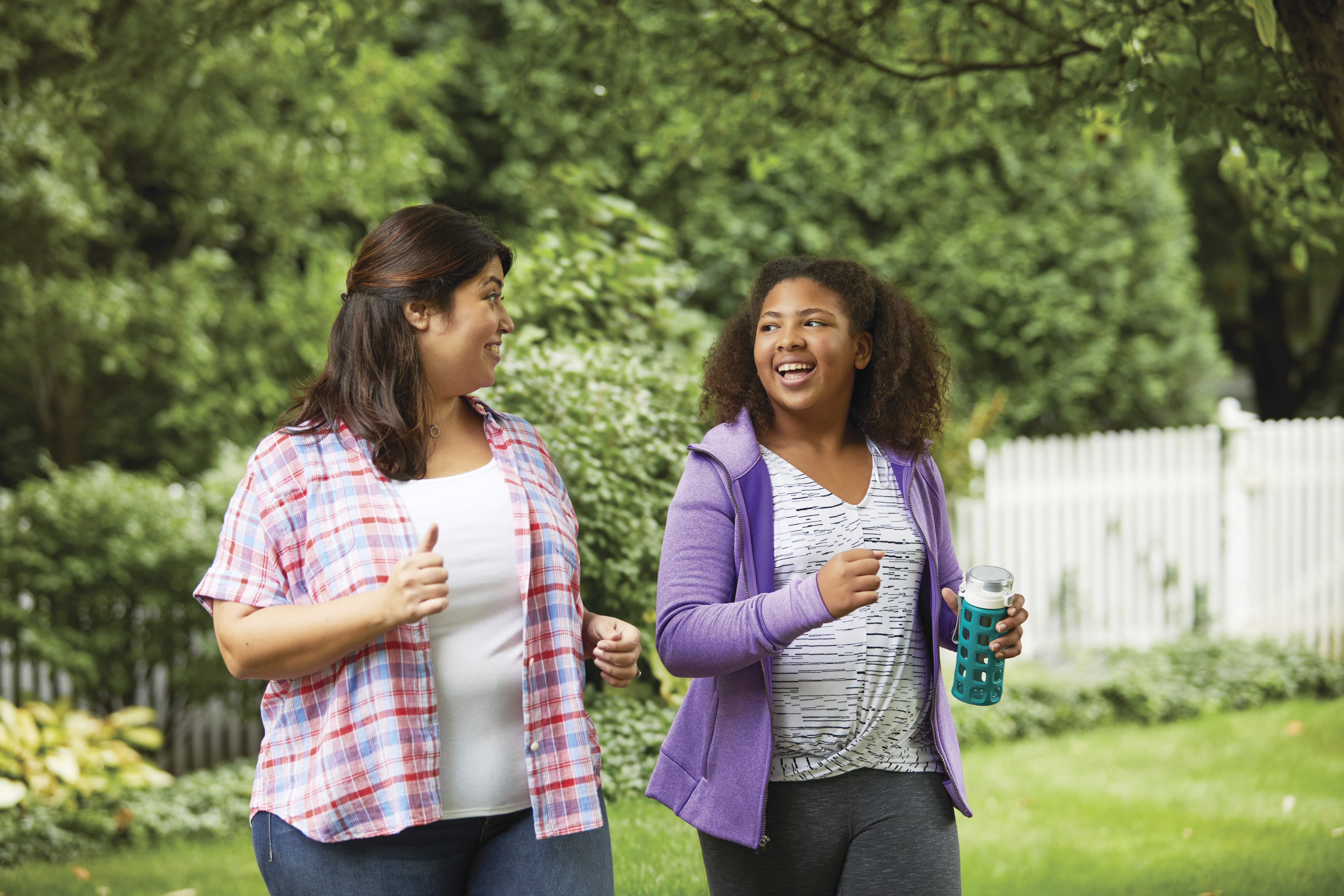 Two women walking and smiling at each other