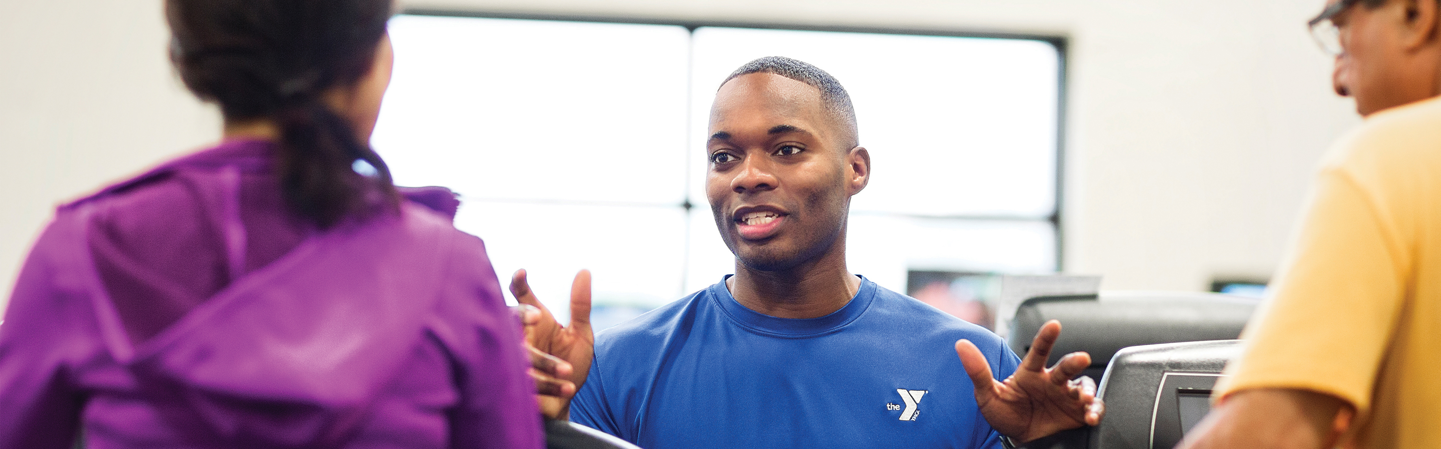 A Healthy Living staff, coaching two YMCA members.