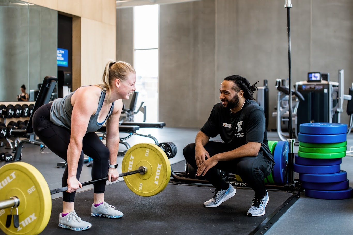 Healthy Living Coach cheering on YMCA member while lifting weights