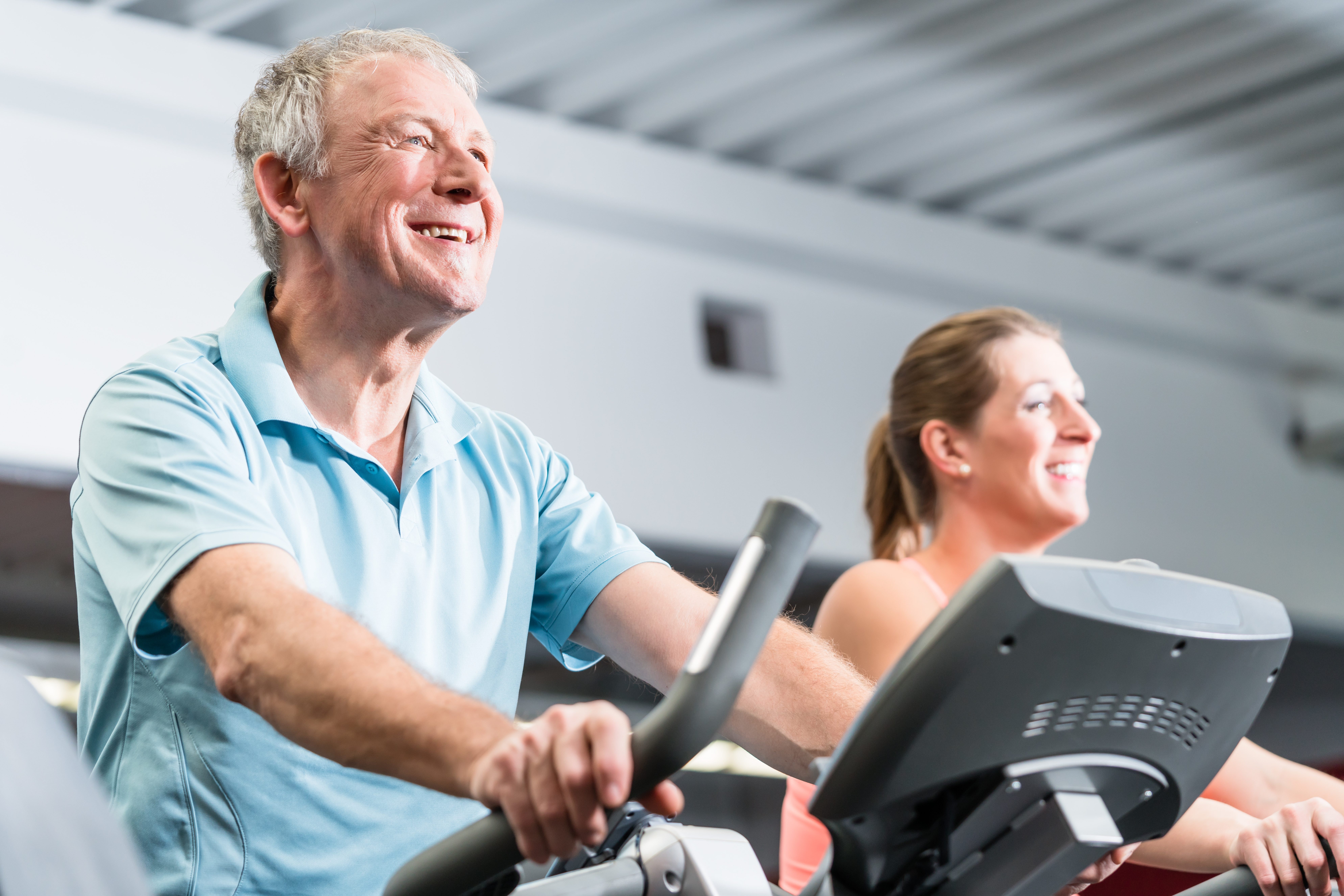 Photo of an older man biking at the gym