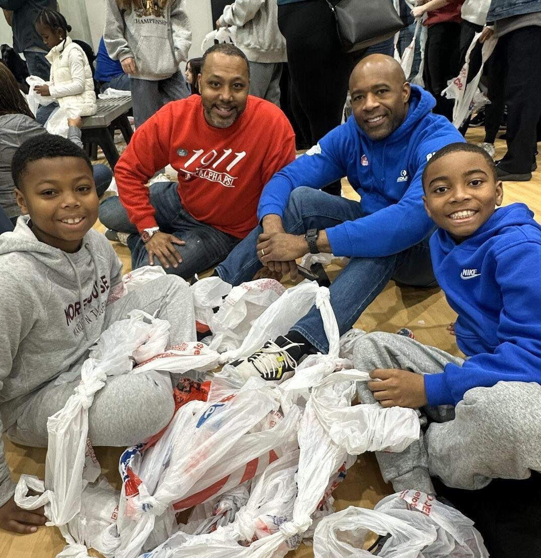 A group of people posing with plastic bags at MLK Day 2025 at Cleaver Family YMCA.