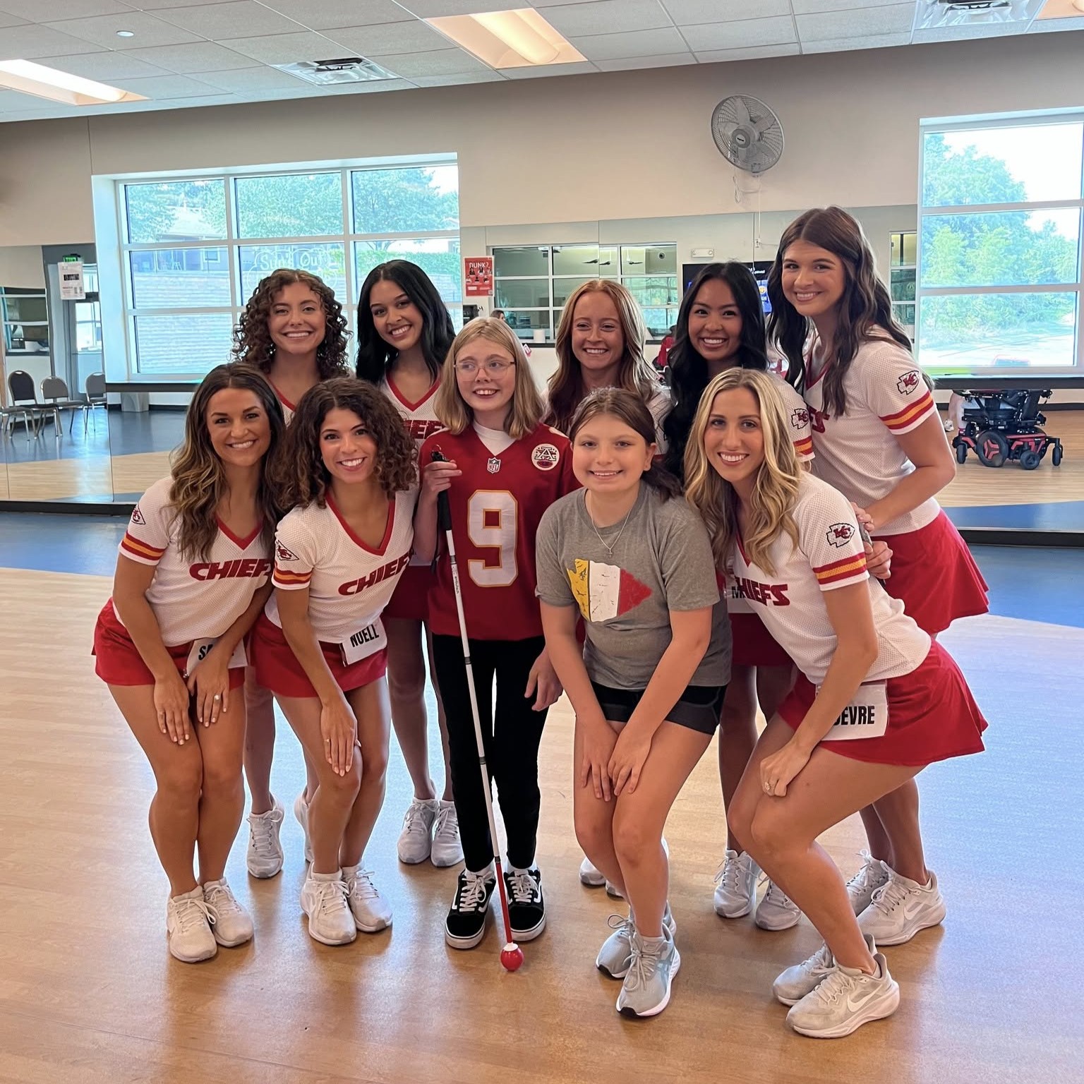 Photo of a Challenger participant posing with the KC Chiefs Cheerleaders.