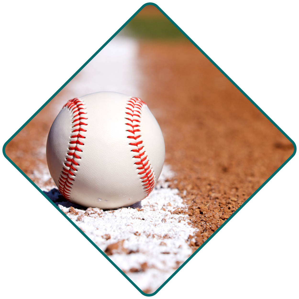 Close-up of a baseball sitting on the baseline on a field