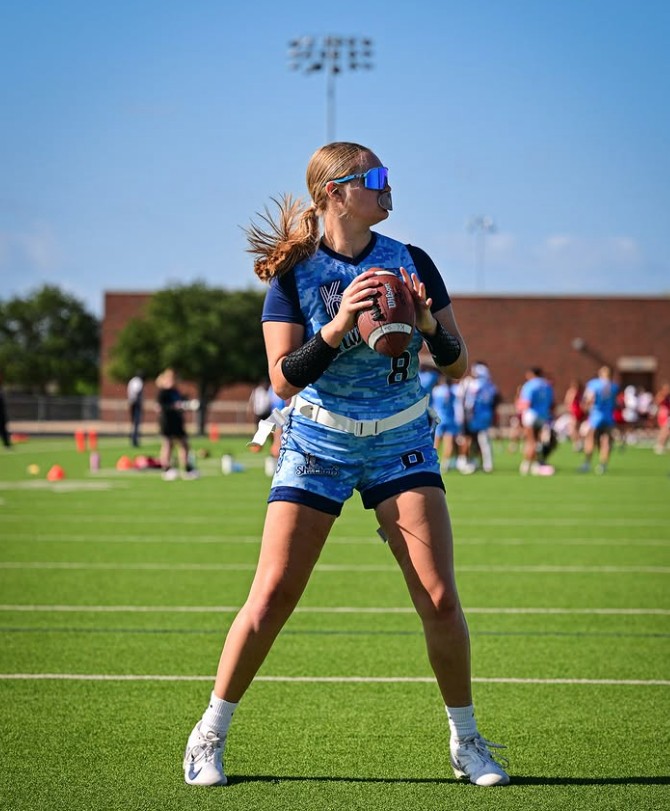 Kate, a flag footall quarterback, prepares to throw a ball