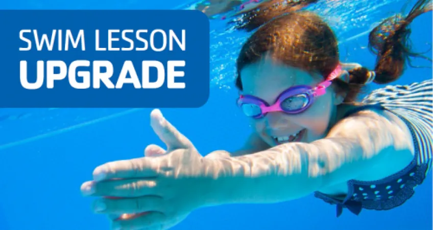 Young girl swimming under water with goggles on. 