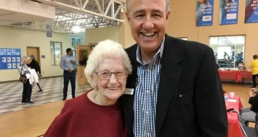 Thelma McDonnell smiles for a photo with David Byrd, Greater Kansas City YMCA President and CEO, at her 101st birthday celebration. 