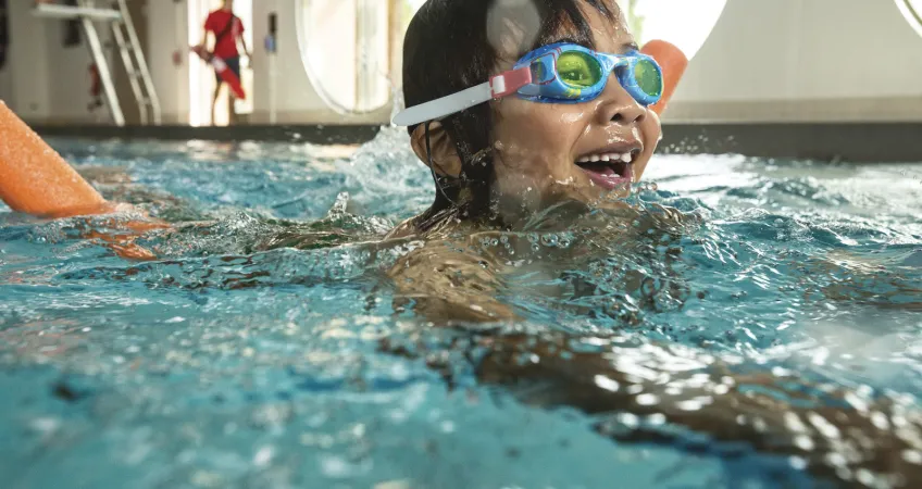 Child smiling while swimming at the Greater Kansas City Y.