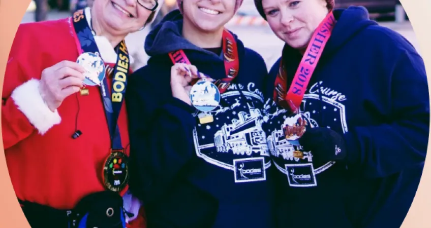 3 competitors hold their medals up after the Candy Cane Course.