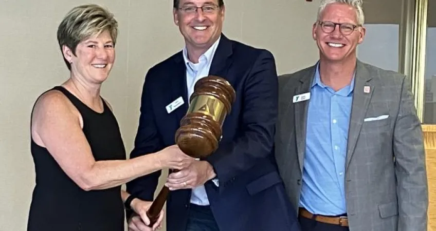 Outgoing Chief Volunteer Officer John Passanisi, center, passes the gavel to Dr. Michelle Robin, incoming Chief Volunteer Officer. Mark Hulet, Interim CEO, is on the right.