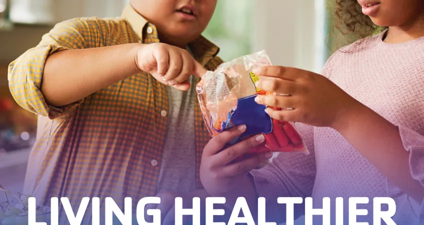 Two young people look at a bag of carrots to read the nutrition info. Text: "Living healthier lifestyles, diabetes awareness month"