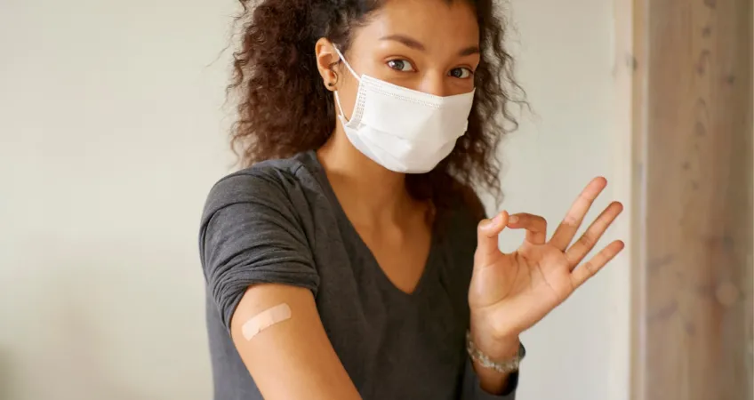 Graphic of woman with bandaid on arm making "ok" sign with hand. With text banner "Getting Your Vaccine is Easy!", "Vaccines provided by TMC/University Health", and "Starting July 6th"..