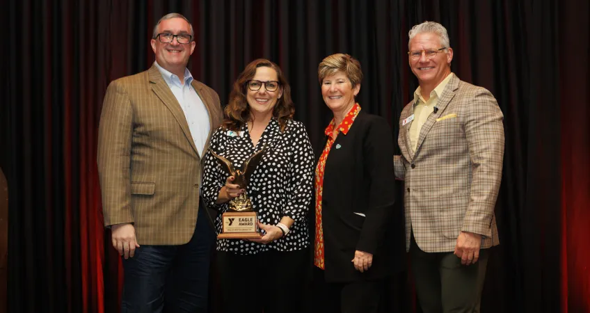 Representatives from the Cleaver Family YMCA accept the Eagle Award. Pictured from left to right: Aaron Lukken, Tami Carolan, Dr. Robin and Mark Hulet.