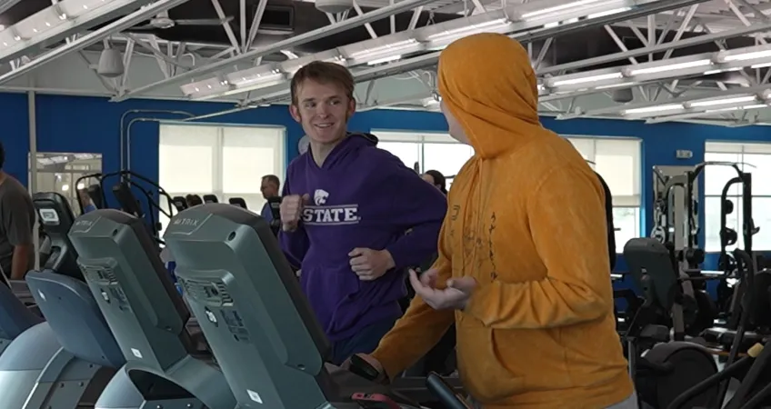 An adult mentor and youth match with Big Brothers Big Sisters enjoy time together exercising on treadmills at a greater Kansas City location as part of the Y's partnership