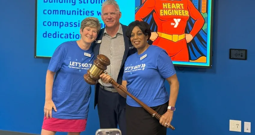 Photo of outgoing Chief Volunteer Officer Dr. Michelle Robin, President and CEO Mark Hulet, and Incoming Chief Volunteer Officer Dr. Andrea Hendricks. Hendricks is holding a large gavel signifying the change in Board of Directors leadership.