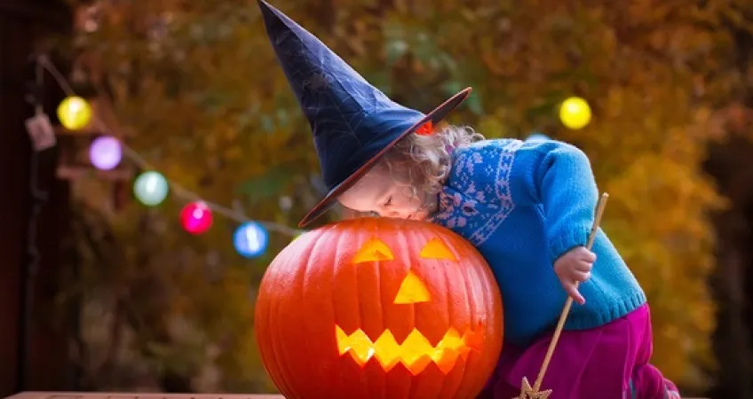 Young girl looks inside jackolantern
