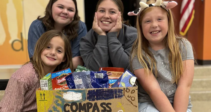 Group of students from Compass Y Club poses with box of food collected for YMCA of Greater Kansas City food pantries.