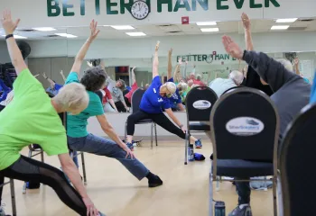 Older adults seated and stretching in Active Older Adults Group Exercise Class.