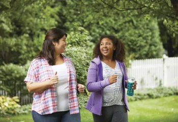 Two women walking and smiling at each other
