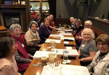 Platte County South Members gather around a long dinner table at a local restaurant.