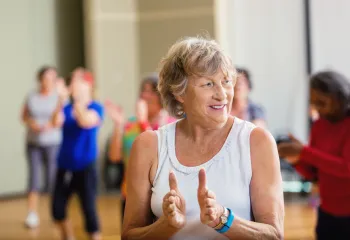 Photo of an active older adult participating to a group class.