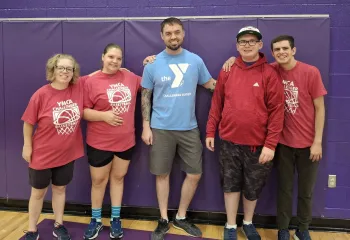 Photo of a buddy posing with four challenger athletes after playing basketball.