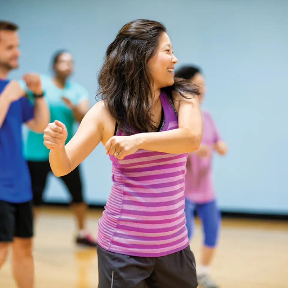 Adults smiling and swinging their arms in Kansas City YMCA Group Exercise Class.