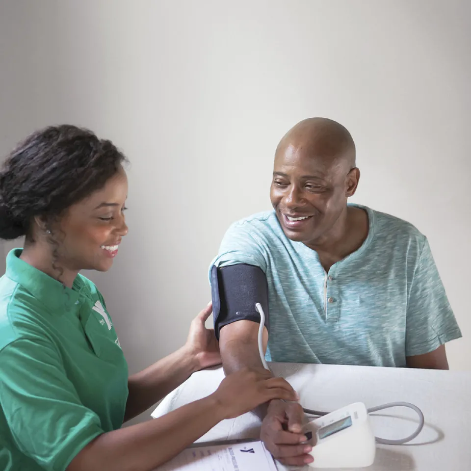 Man getting his blood pressure checked by Kansas City YMCA team member.