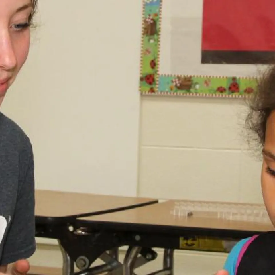 Kansas City YMCA employee assisting child in classroom setting.