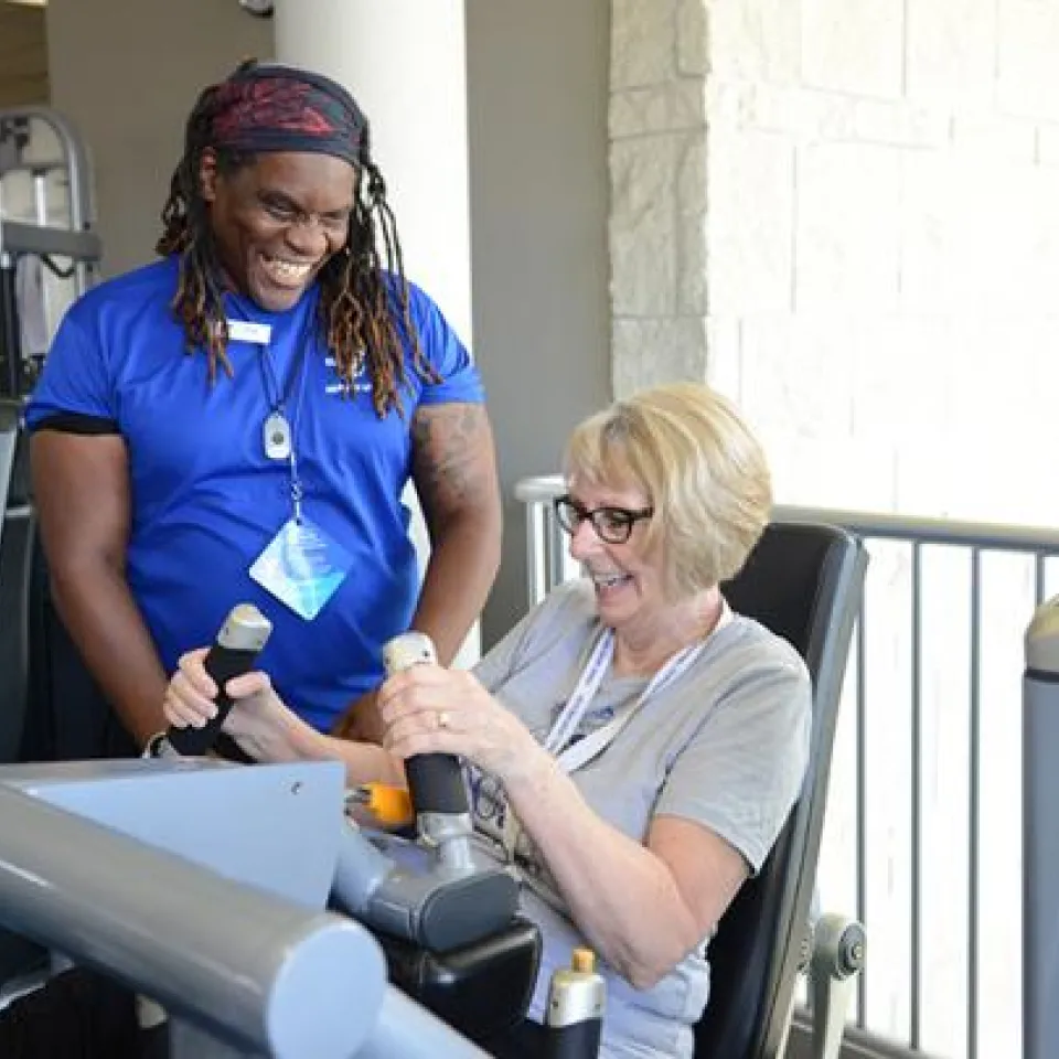 Personal trainer assisting an individual while exercising