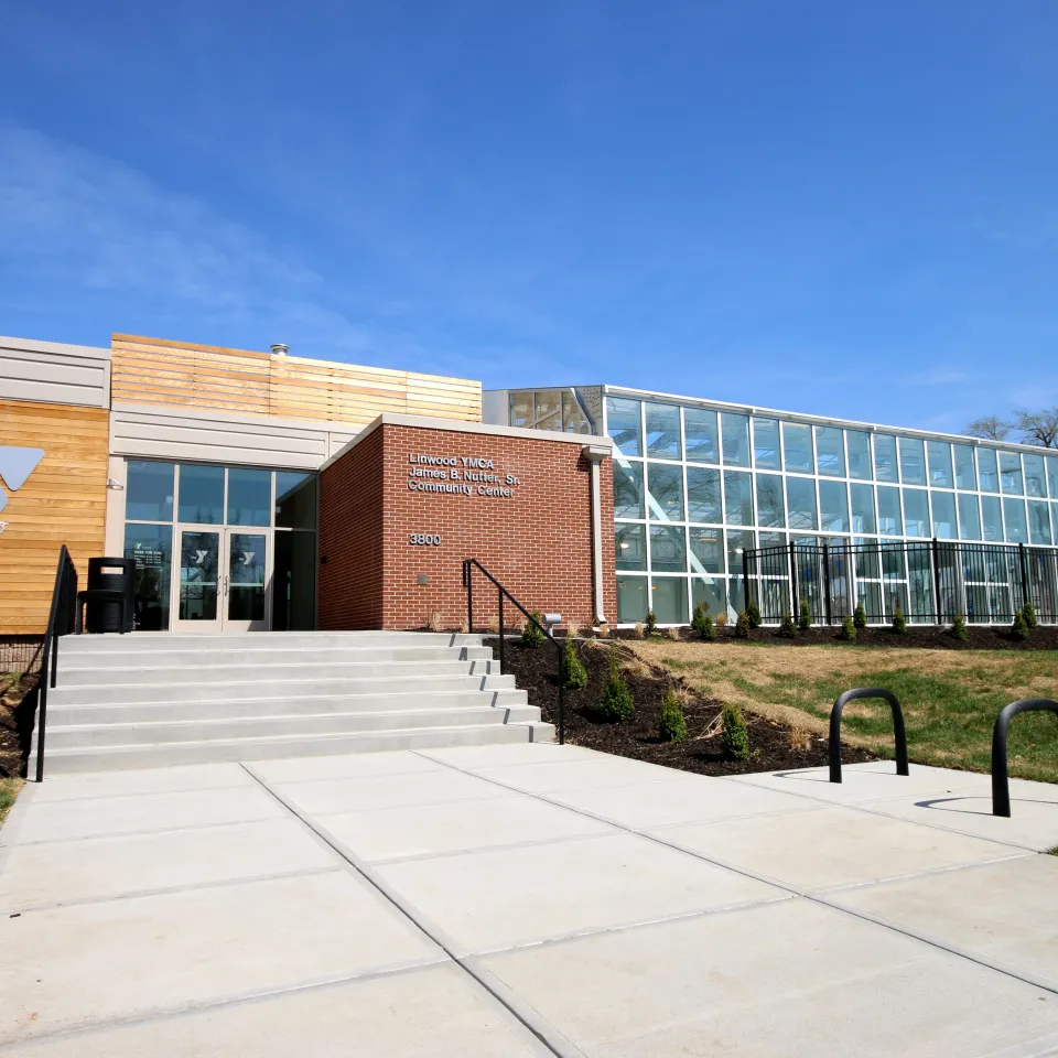 Exterior photo of Linwood YMCA/James B. Nutter, Sr. Community Center. Features Y Logo on the left side of the entrance with the building name on the right, even further to the right is floor to ceiling glass walls.