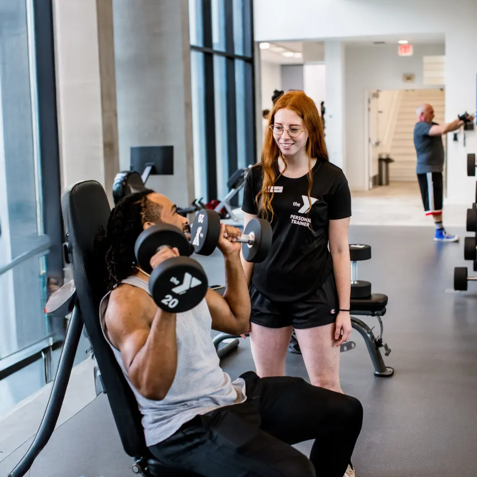 Picture of a training helping a YMCA member during member orientation session.