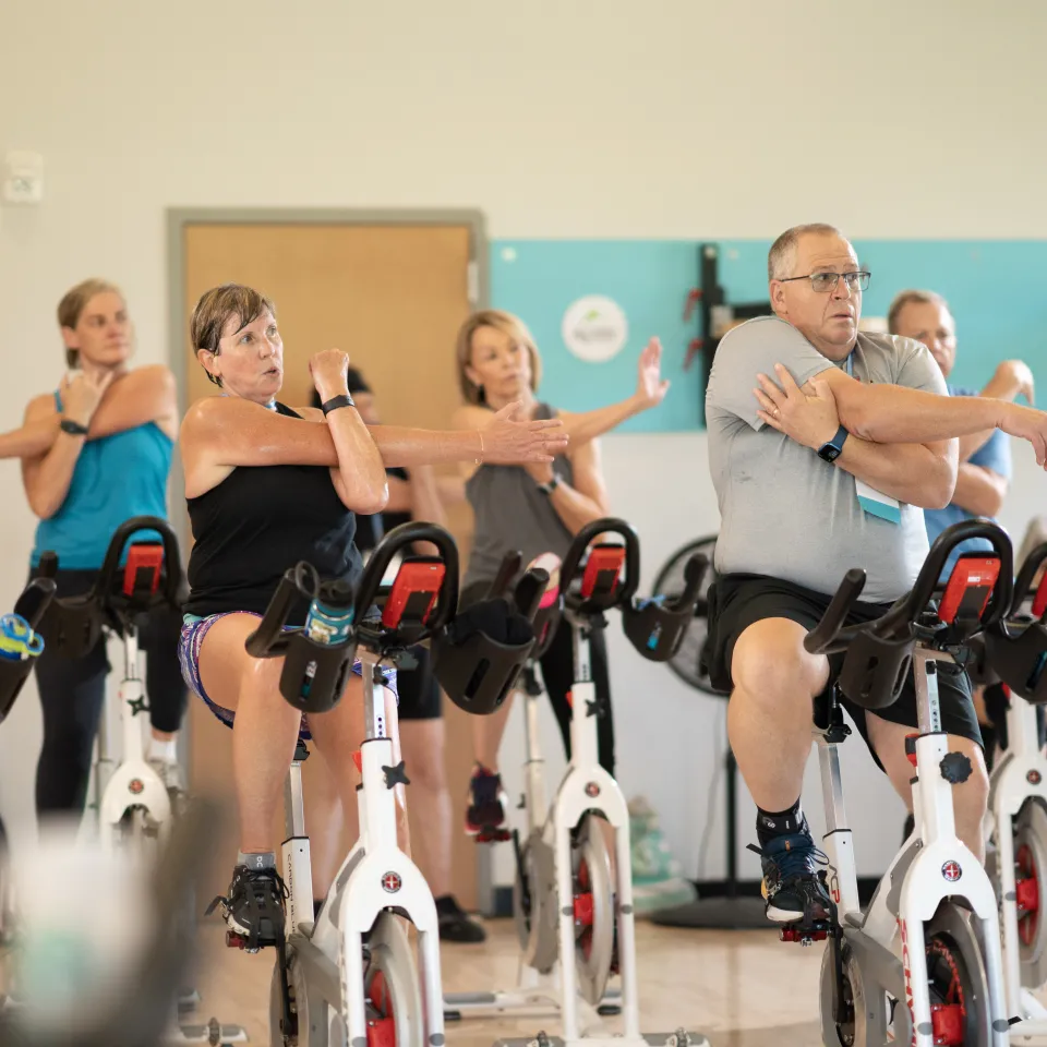 Photo of people pedaling and stretching during a group clas.s