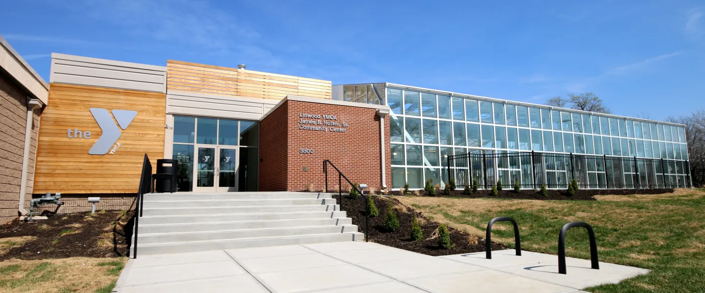 Exterior photo of Linwood YMCA/James B. Nutter, Sr. Community Center. Features Y Logo on the left side of the entrance with the building name on the right, even further to the right is floor to ceiling glass walls.