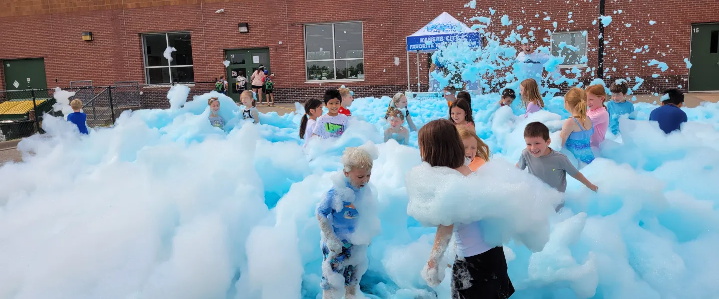 Kids play in blue foam at summer day camp