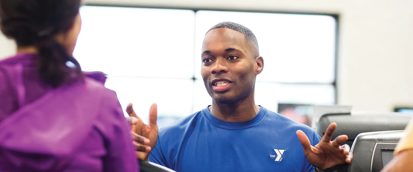 A Healthy Living staff, coaching two YMCA members.