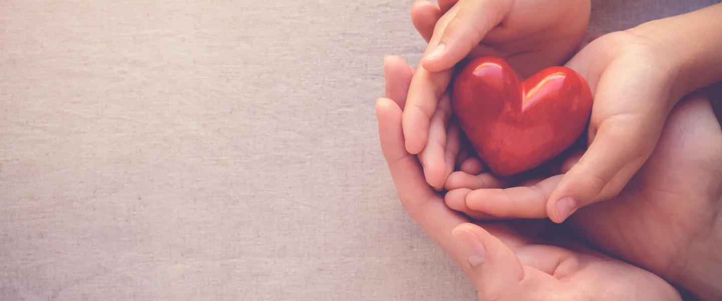Photo of two people holding a heart-shaped object