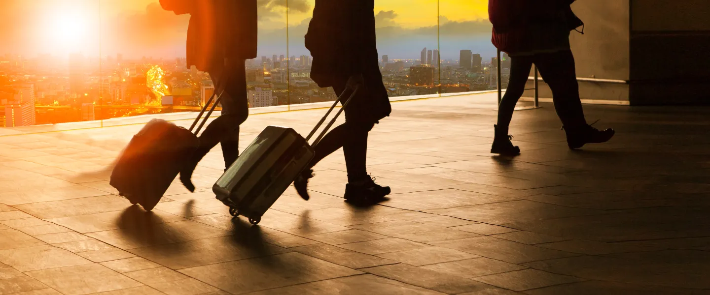 Photo of people walking with suitcases.