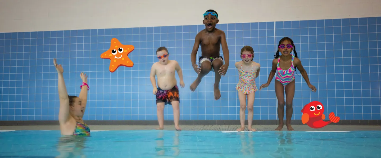 Photo of 4 kids about to jump in an indoor pool.