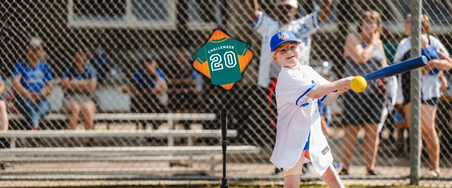 Photo of a challenger athlete playing baseball with a badge Teal Challenger baseball jersey with the number 20, commemorating the YMCA Challenger Program's 20th anniversary.