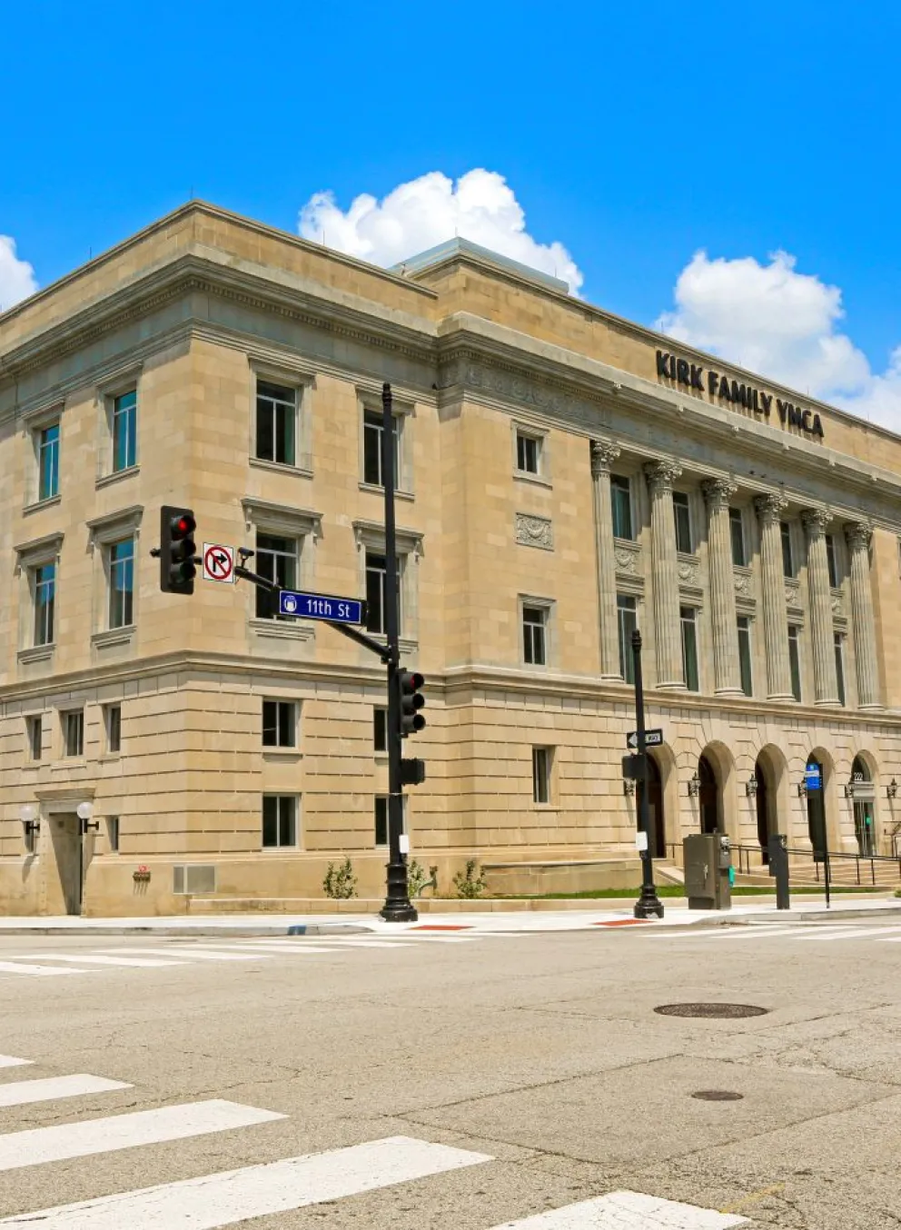 Photograph of the Kirk Family YMCA building from across the street, with kiosk visible from the east entrance of the building.