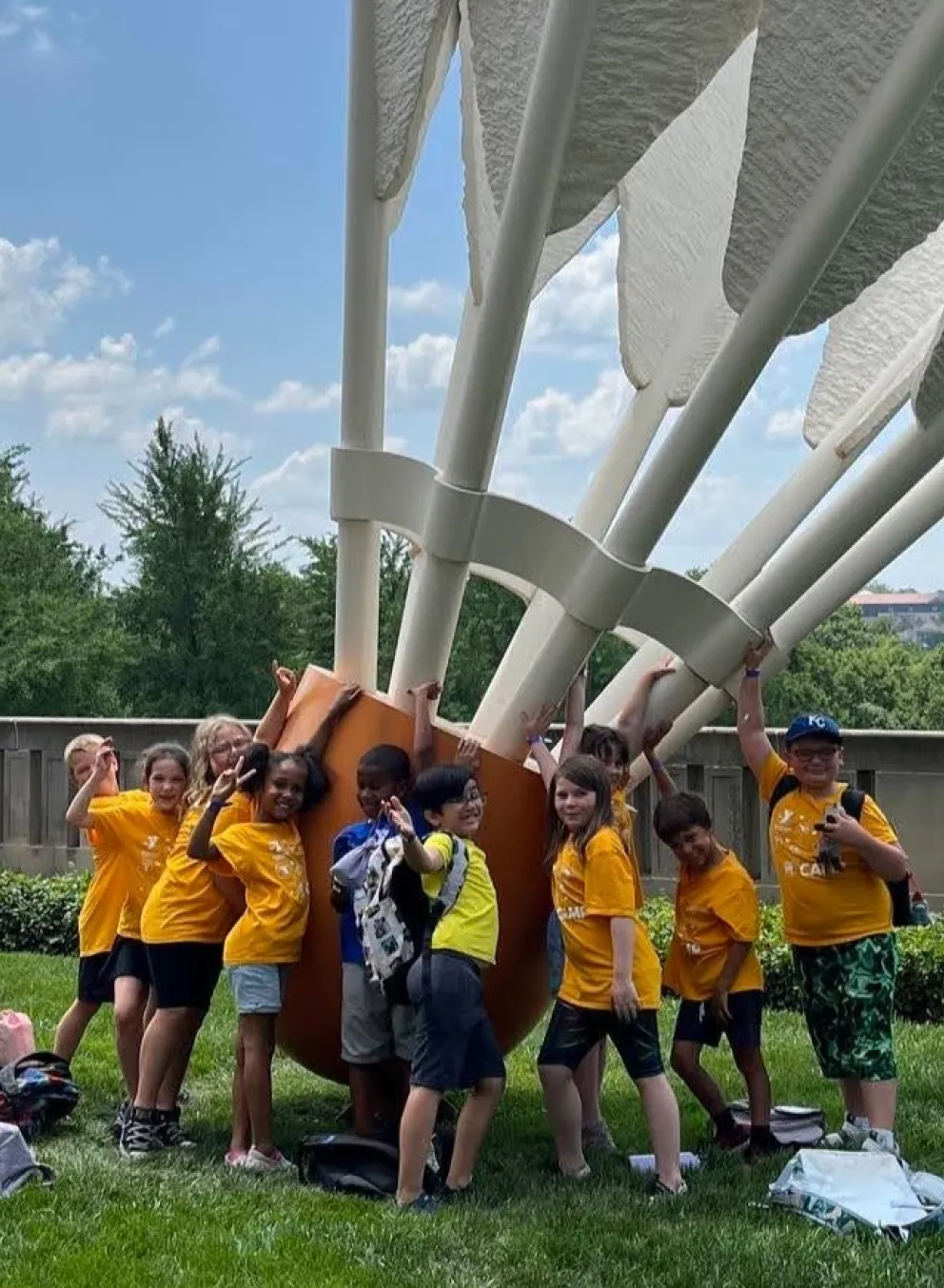 Photo of group of summer day campers standing in front of large shuttlecock sculpture